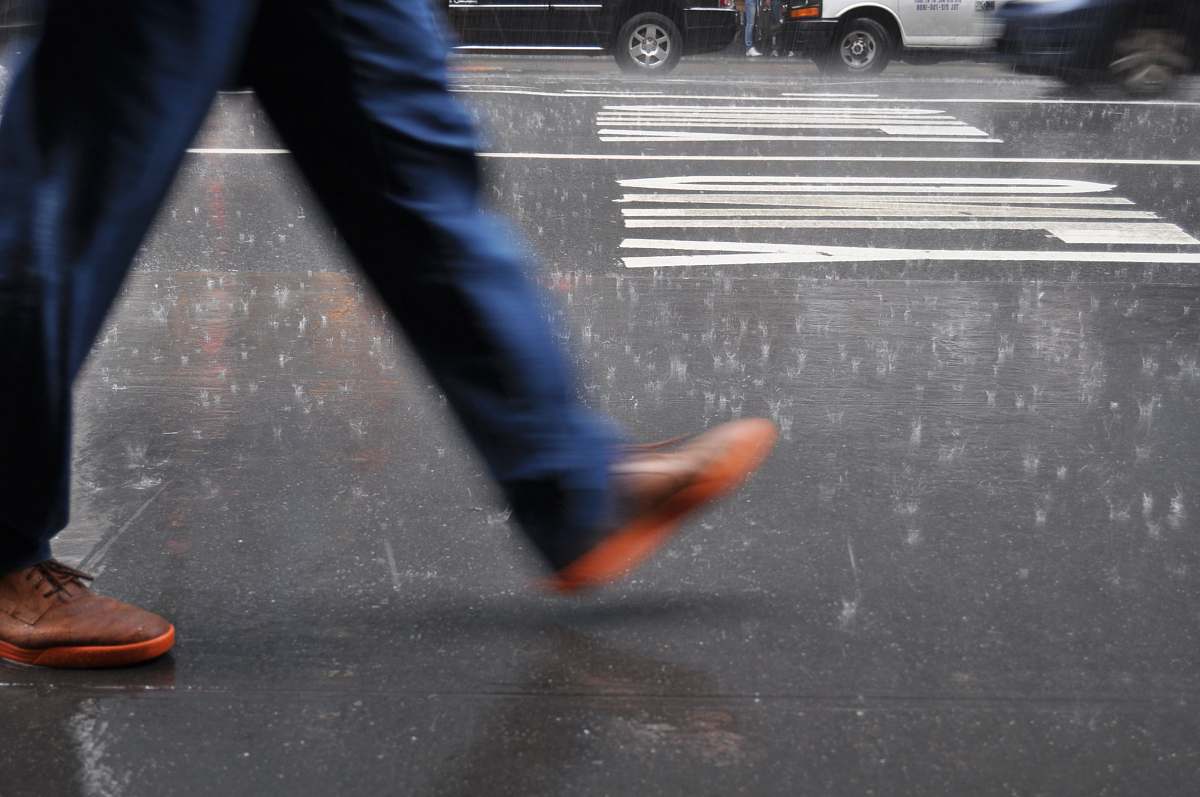 united states man wearing blue pants walking on street tarmac